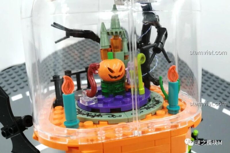 Cận cảnh cảnh quan bên trong đèn lồng của bộ lắp ghép Đèn Lồng Halloween Sembo 605021, với bí ngô trung tâm và nến.