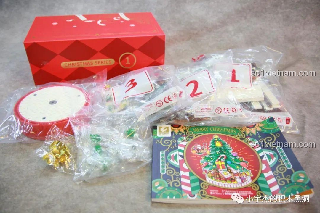 Nội dung bên trong hộp số 1 của bộ lắp ráp Cây Thông Giáng Sinh Nhạc Hội SEMBO 605025, bao gồm sách hướng dẫn và các túi mảnh ghép.