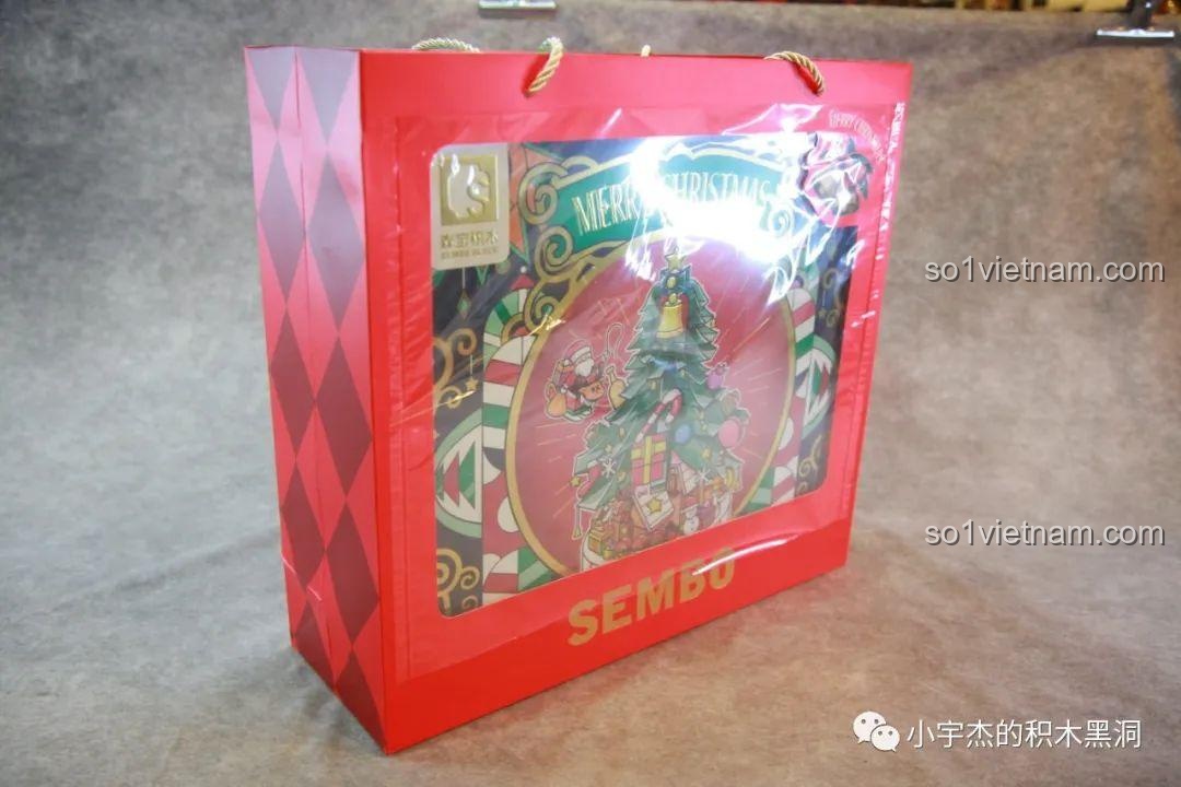 Góc nhìn nghiêng của túi giấy quà tặng SEMBO 605025, cho thấy phần trong suốt và hộp Cây Thông Giáng Sinh Nhạc Hội bên trong, thể hiện sự sang trọng.