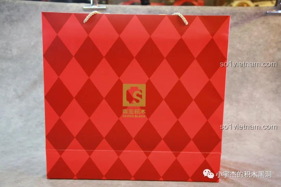 Túi giấy màu đỏ rực rỡ với logo SEMBO, dùng để đựng bộ lắp ráp Cây Thông Giáng Sinh Nhạc Hội SEMBO 605025, rất phù hợp làm quà tặng.