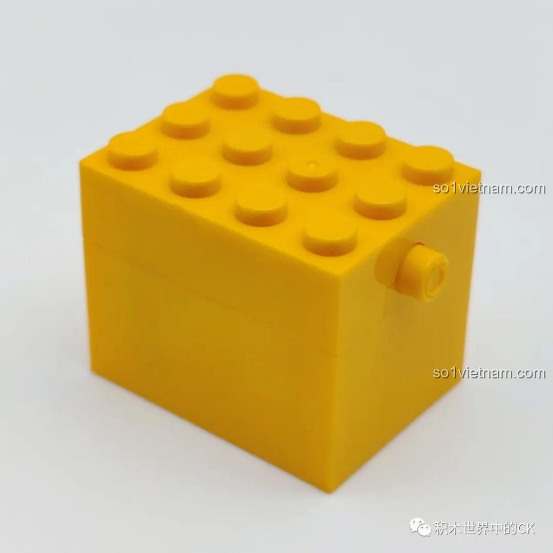 Chi tiết hộp nhạc màu vàng của bộ lắp ráp SEMBO 605026 Bó Hoa Giáng Sinh, có các nút bấm trên bề mặt.