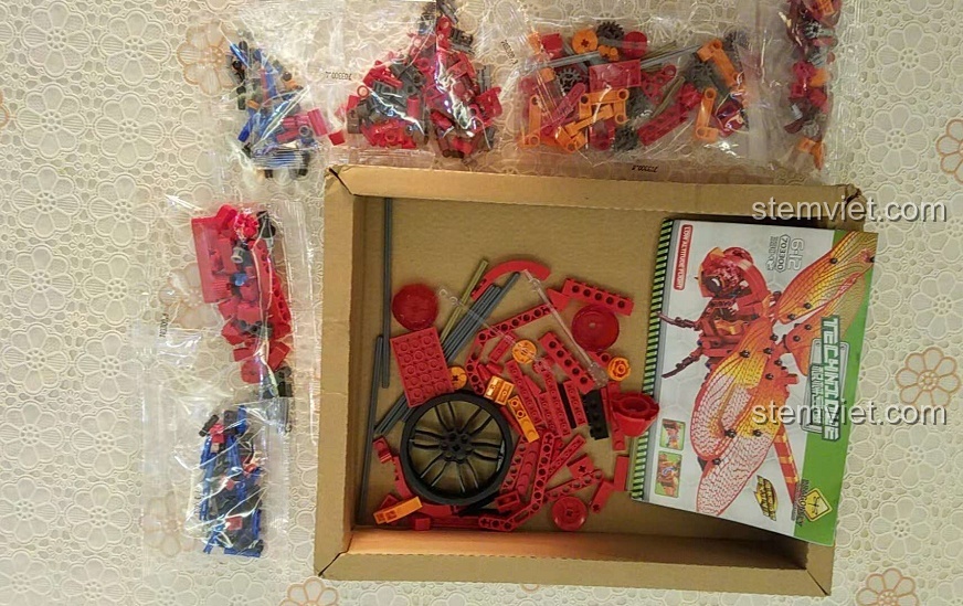 Các mảnh ghép Sembo 703300 Chuồn Chuồn Đỏ Cơ Khí được phân loại trong túi, sẵn sàng cho bé trai lắp ráp.