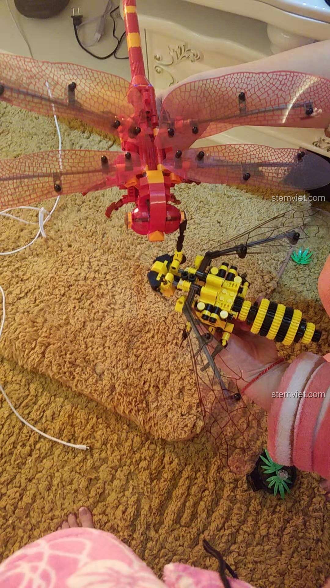 Mô hình Chuồn Chuồn Đỏ Cơ Khí Sembo 703300 và mô hình Ong Cơ Khí Sembo 703200 so sánh kích thước với tay người, đồ chơi lắp ráp lớn.