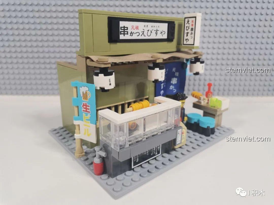 Mô hình hoàn chỉnh Quán Izakaya mini 601073 với một minifigure đứng trước quầy, sẵn sàng phục vụ xiên nướng thơm ngon.