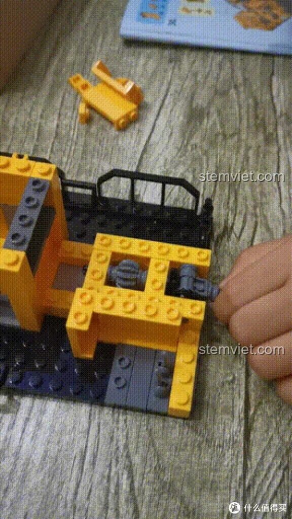 Tay bé đang lắp ráp phần thân xe SEMBO Lưu Lạc Địa Cầu, chi tiết bánh răng và khung xe dần hiện ra.