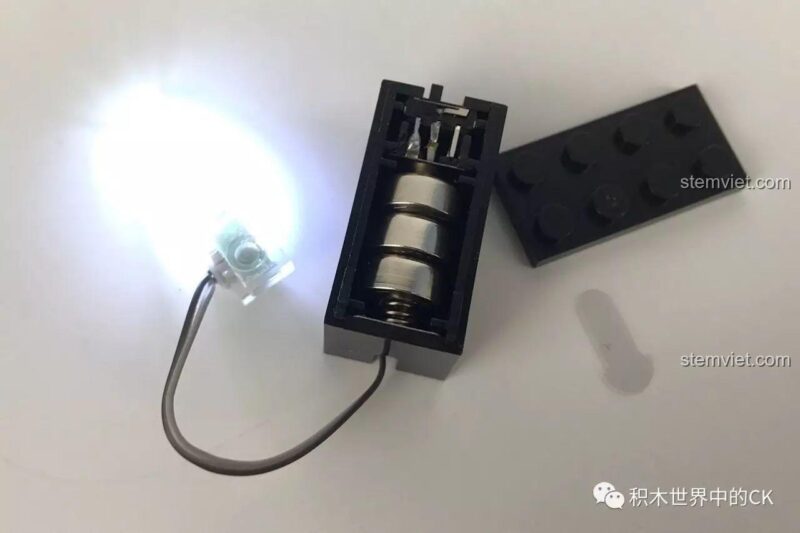 Khối đèn LED đang phát sáng và cấu tạo bên trong với 3 viên pin cúc áo.