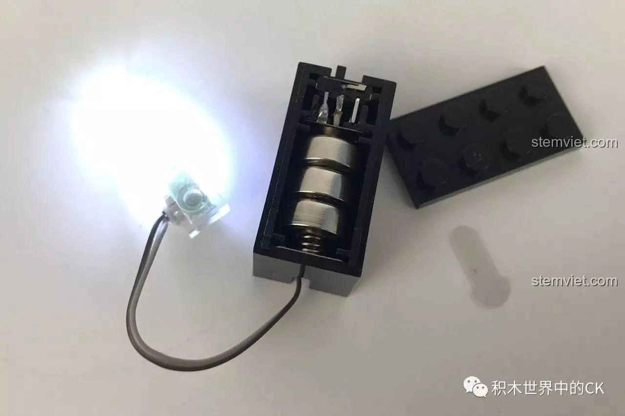 Viên gạch phát sáng của bộ lắp ráp SEMBO SD3351 Lâu Đài U Minh - Bàn Thờ Tế Lễ đã được lắp pin và đang hoạt động, cho thấy ánh sáng mạnh mẽ.