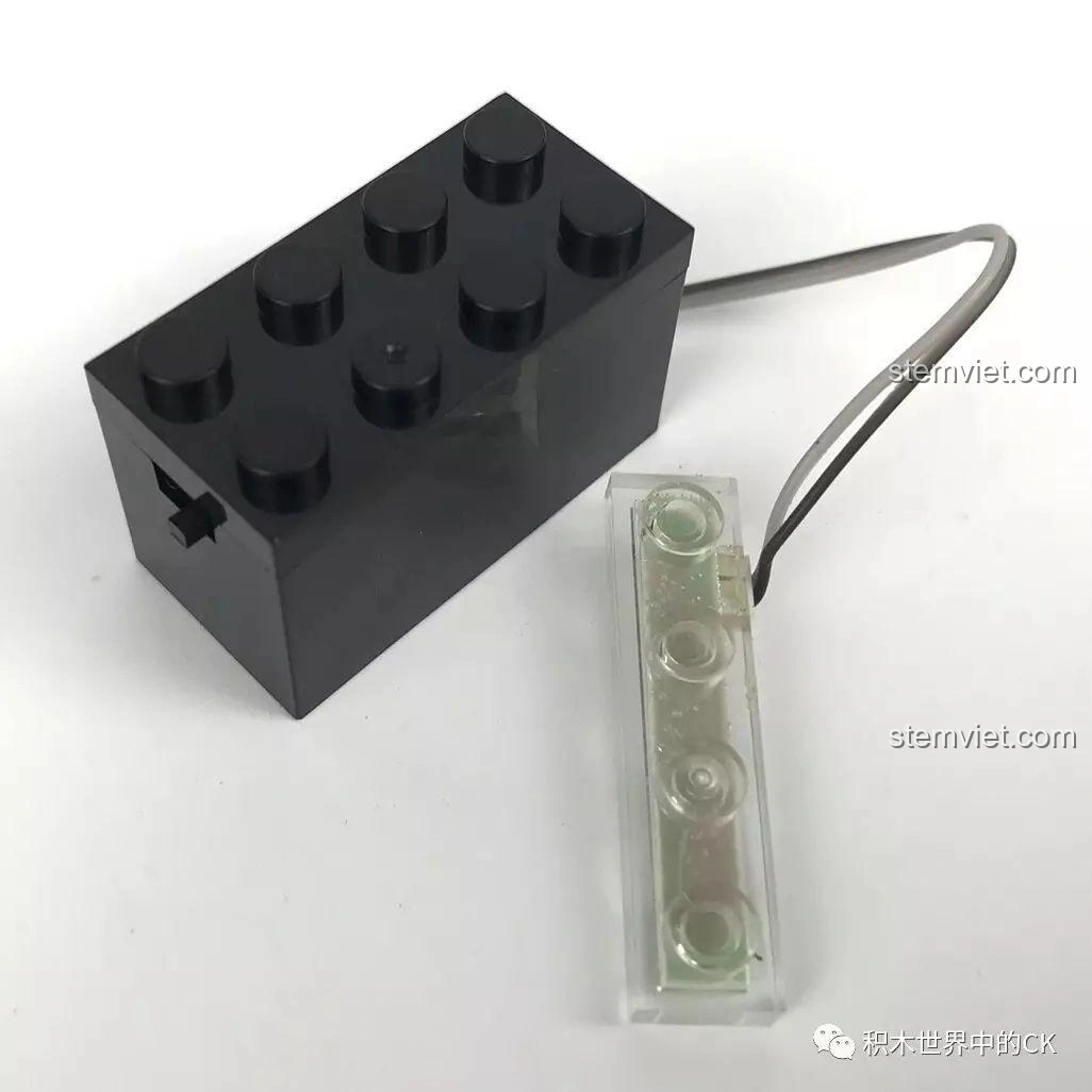 Chi tiết viên gạch phát sáng (light brick) và dây dẫn đi kèm bộ lắp ráp SEMBO SD3351 Lâu Đài U Minh - Bàn Thờ Tế Lễ, tạo hiệu ứng ánh sáng độc đáo.