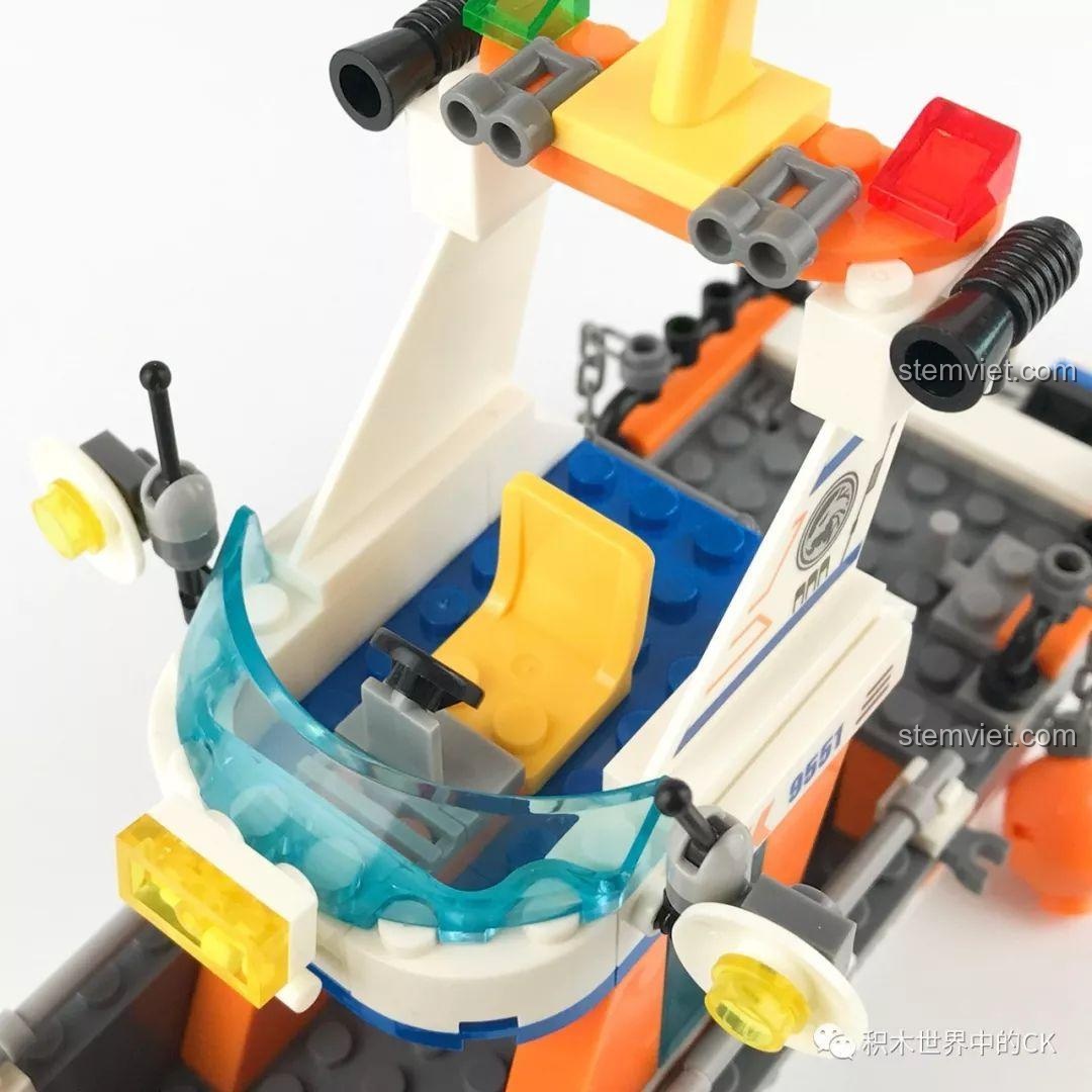 Buồng lái của tàu cứu hộ với ghế ngồi màu vàng, vô lăng và kính chắn gió.