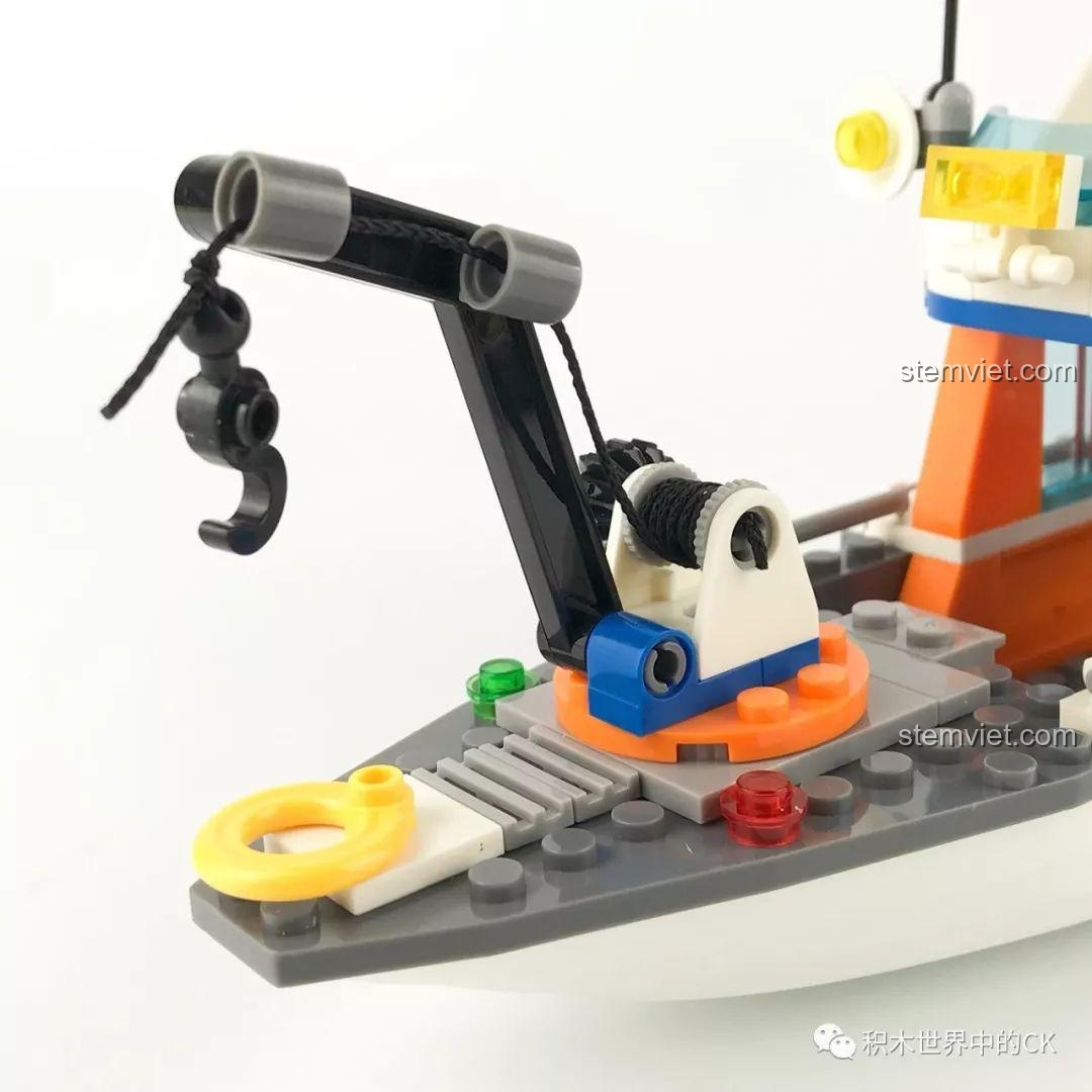 Chi tiết phần mũi tàu với cần cẩu, tời và phao cứu sinh màu vàng.