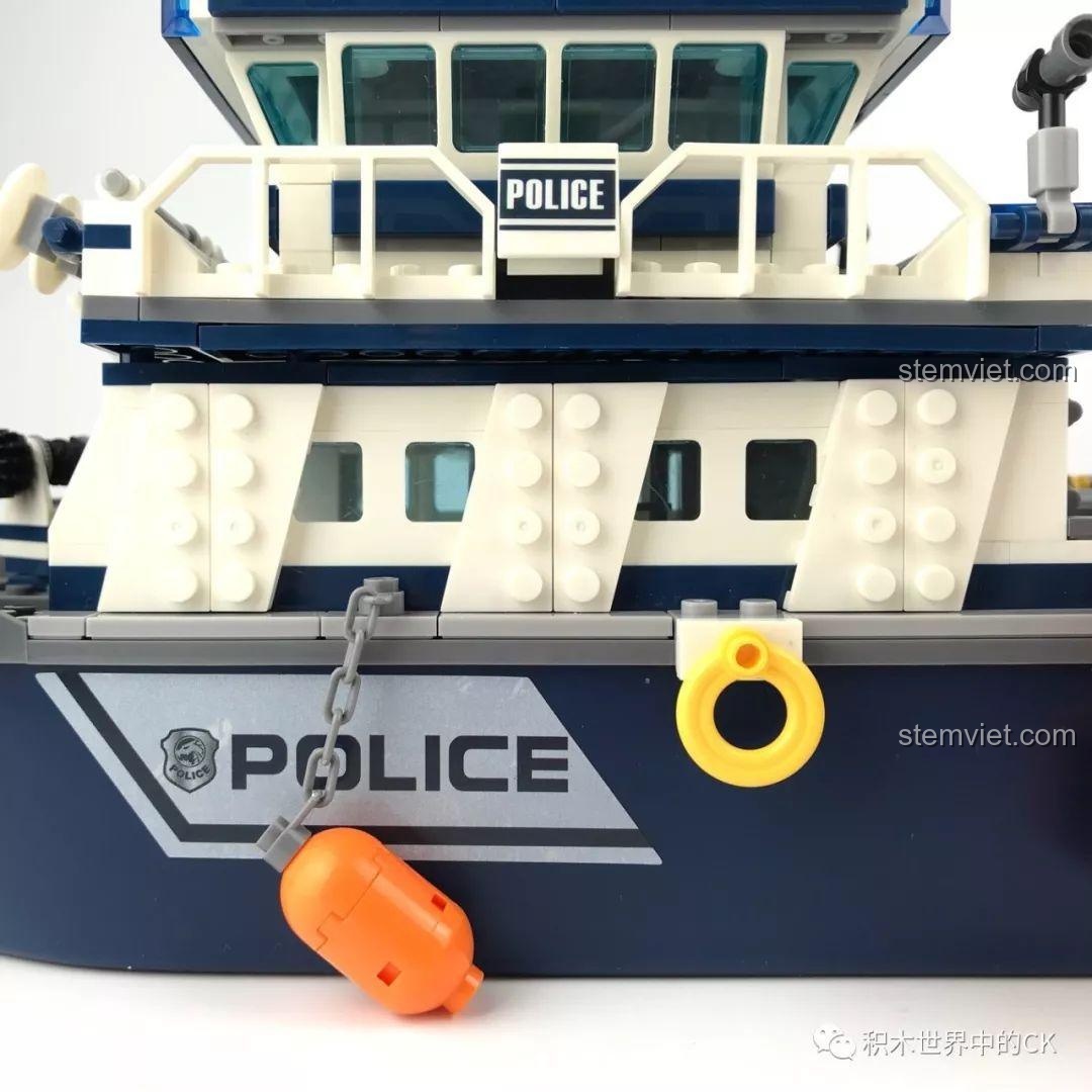 Thuyền cứu hộ màu cam được nâng lên cao bằng hệ thống nâng hạ trên Tàu Tuần Tra Cảnh Sát SD9796.