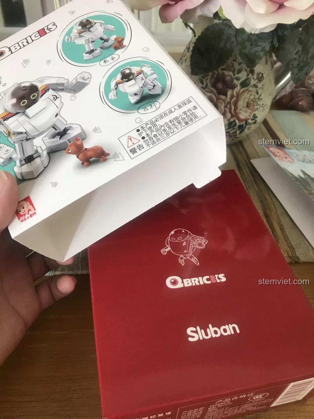 Cận cảnh hộp sản phẩm Sluban M38-B0761E Robot Q-Bricks đang được mở theo kiểu kéo trượt, rất tiện lợi. Trải nghiệm Sluban 761E Robot Q-bảo vệ.