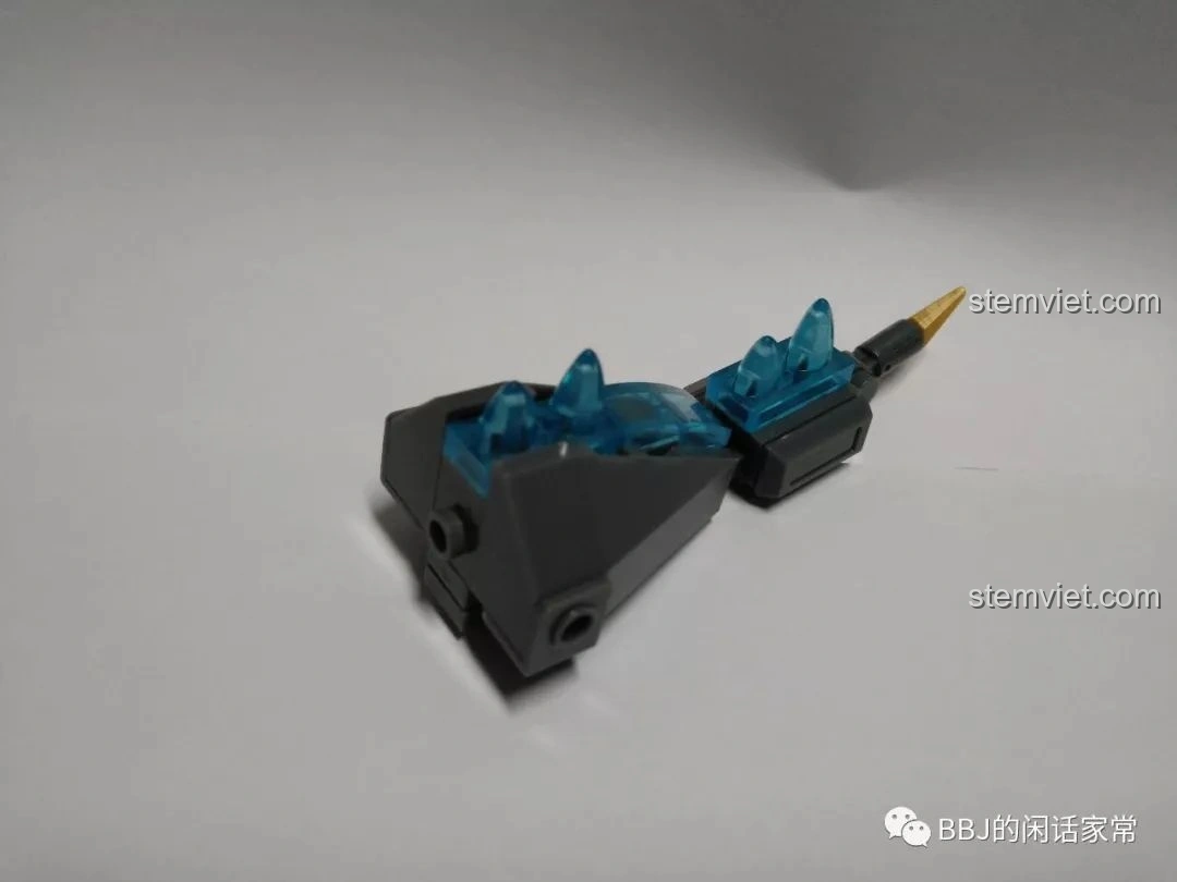 Quá trình lắp ráp phần đuôi của mô hình Sluban B0761A Godzilla chibi M38-B0761A, với các chi tiết gai lưng màu xanh trong suốt.