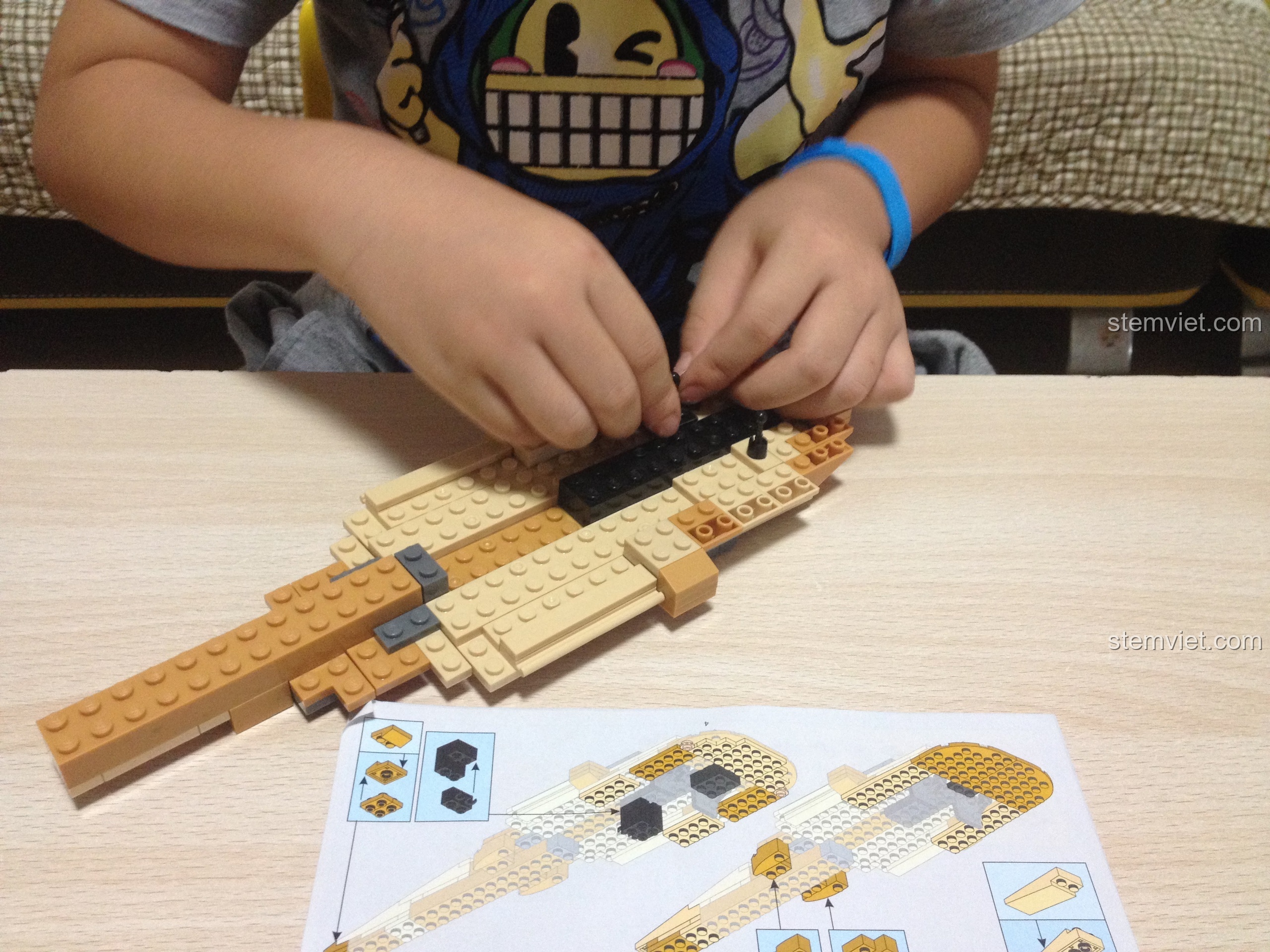 Bé trai 6 tuổi đang lắp ráp phần thân của đồ chơi lắp ráp M38B0509 Trực thăng Black Hawk UH-60L, rèn luyện sự khéo léo và tập trung