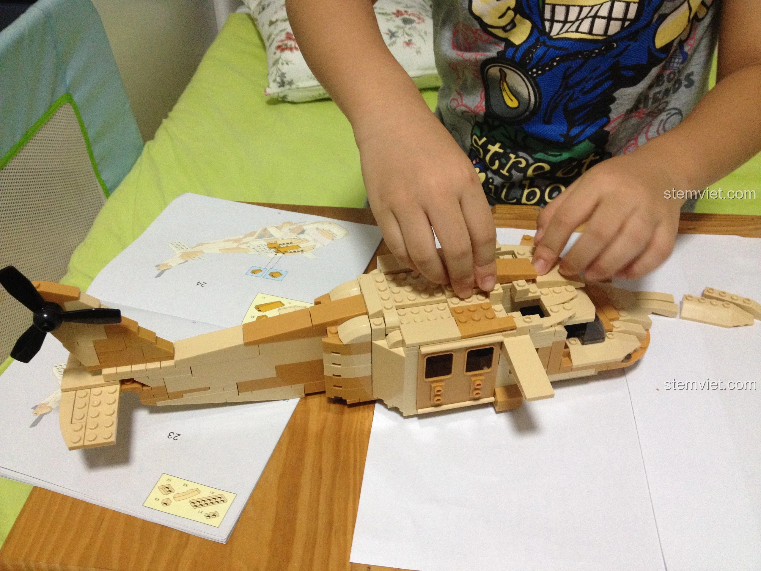 Bé trai lắp cánh quạt chính của mô hình Sluban M38-B0509 Trực thăng Black Hawk UH-60L, bước cuối cùng.