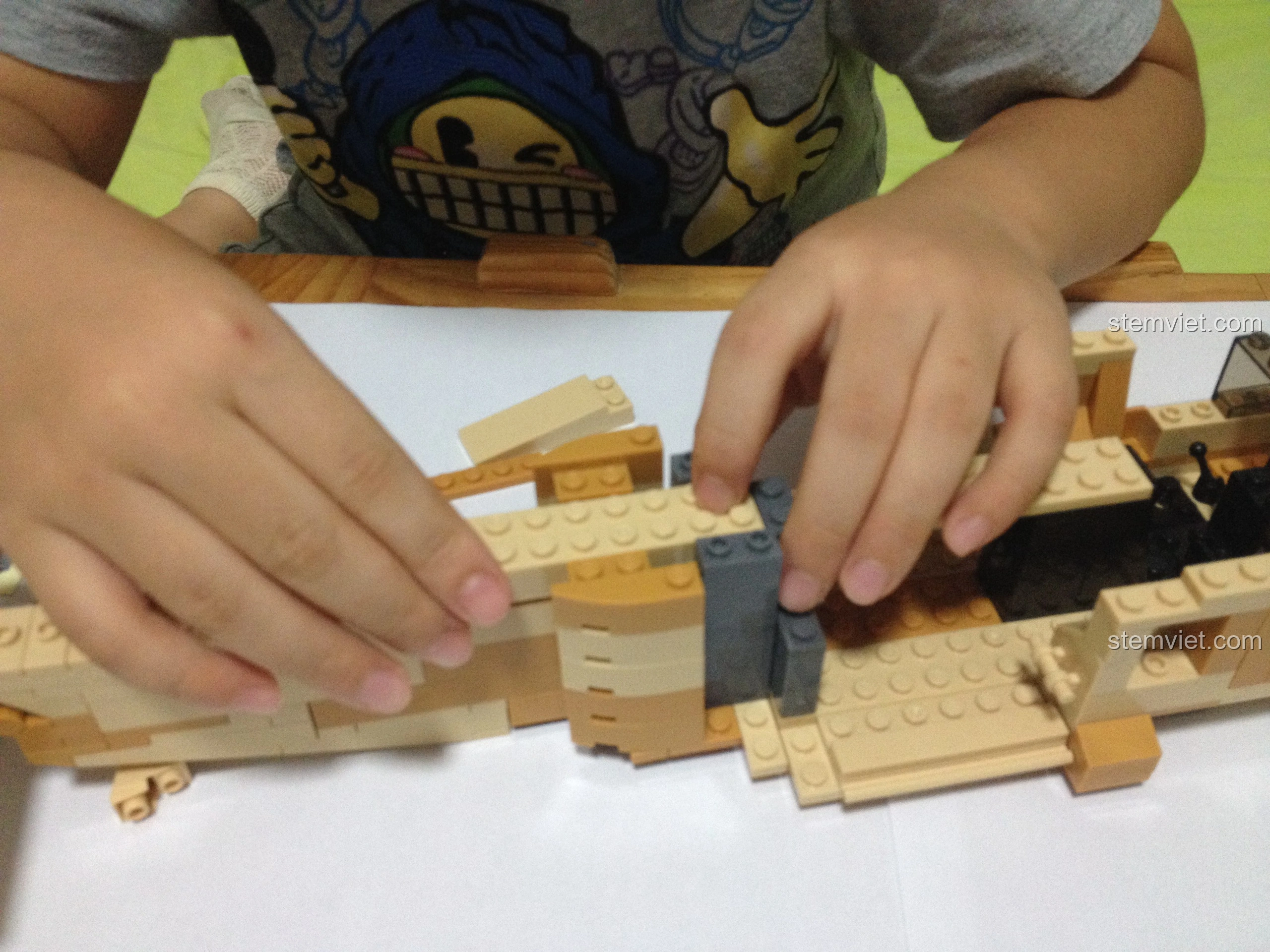 Bé trai lắp ráp phần cánh của mô hình Sluban M38-B0509 Trực thăng Black Hawk UH-60L, các mảnh ghép khớp chặt.