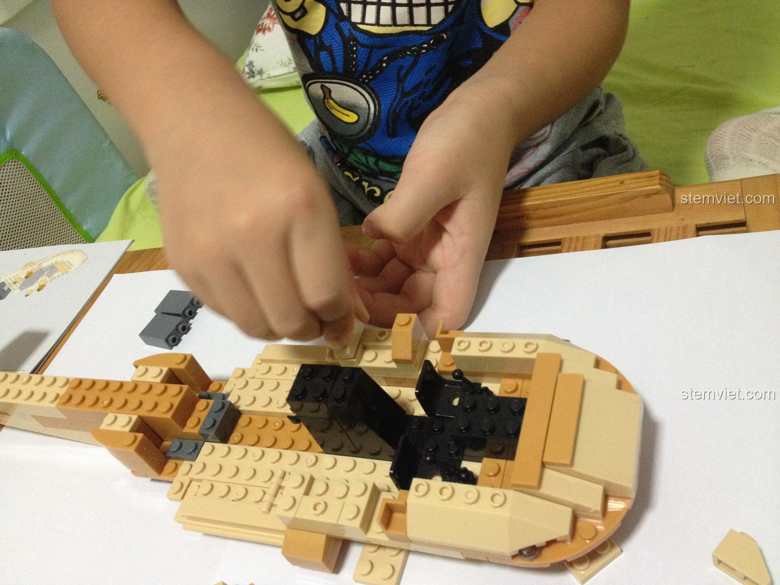 Bé trai lắp ráp khoang lái của mô hình Sluban M38-B0509 Trực thăng Black Hawk UH-60L, đòi hỏi sự chính xác.