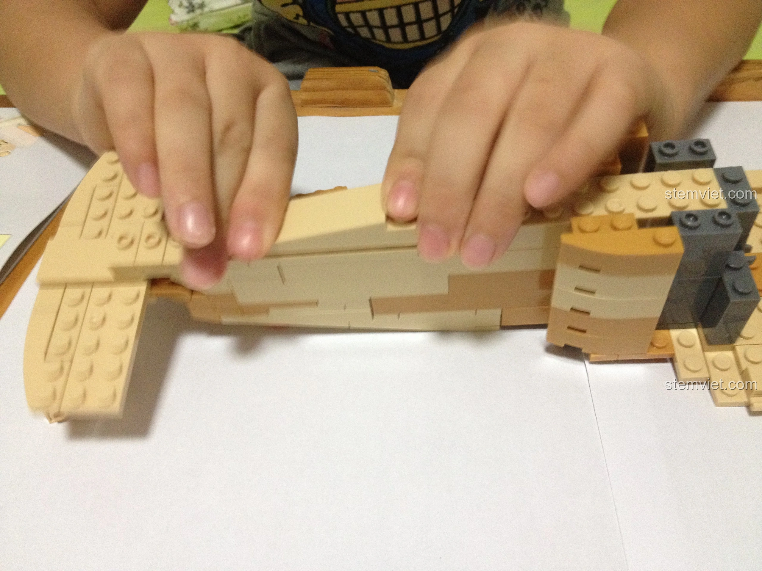 Bé trai lắp phần mái của mô hình Sluban M38-B0509 Trực thăng Black Hawk UH-60L, hoàn thiện thân máy bay.