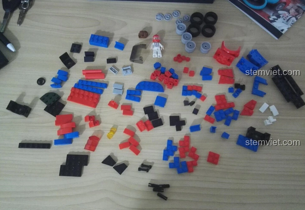 Toàn bộ các mảnh ghép của bộ lắp ghép Sluban M38-B0633E Xe Đua Tốc Độ Cánh Bướm được phân loại trên bàn, sẵn sàng cho quá trình lắp ráp.