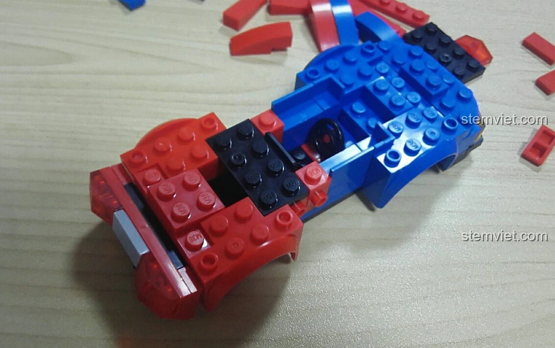 Góc nhìn từ trên xuống của mô hình Sluban M38-B0633E Xe Đua Tốc Độ Cánh Bướm đang trong quá trình lắp ráp, hiển thị khoang lái.