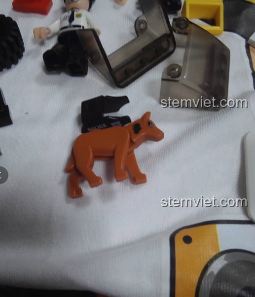 Các chi tiết của bộ lắp ráp Sluban M38-B0639 Xe Tuần Tra SUV Cảnh Sát, nổi bật là chú chó nghiệp vụ màu nâu.