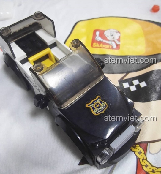 Phần đầu xe của bộ lắp ráp Sluban M38-B0639 Xe Tuần Tra SUV Cảnh Sát đang được lắp, có logo cảnh sát.