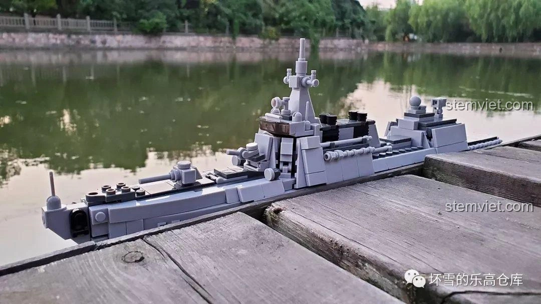 Mô hình Sluban M38-B0700 Tàu Khu Trục Type 055 đặt cạnh hồ nước, tạo cảm giác chân thực như một chiến hạm đang neo đậu.