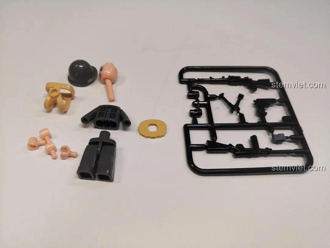 Các mảnh ghép của một minifigure lính tăng và một bộ vũ khí súng máy đi kèm bộ đồ chơi Sluban M38-B0709 Xe Tăng Siêu Nhẹ CV33.