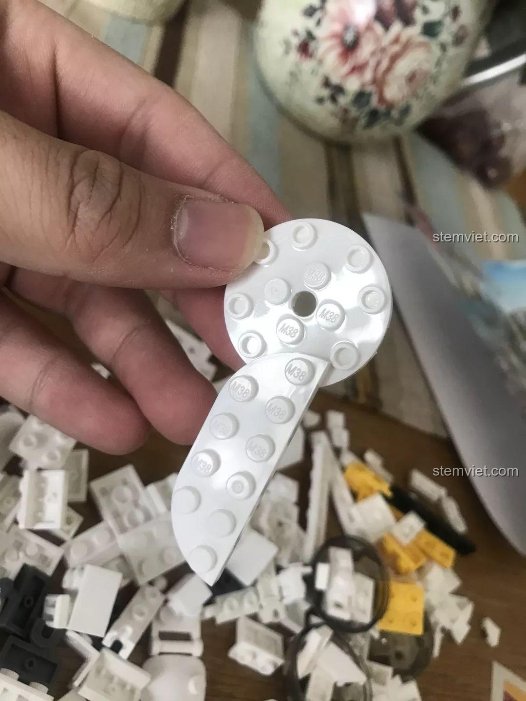 Cận cảnh một mảnh ghép của Sluban M38-B0761E Robot Q-Bricks với logo Sluban được in rõ ràng, cho thấy chất lượng. Đánh giá Sluban M38-B0761E Robot Q-dễ thương.