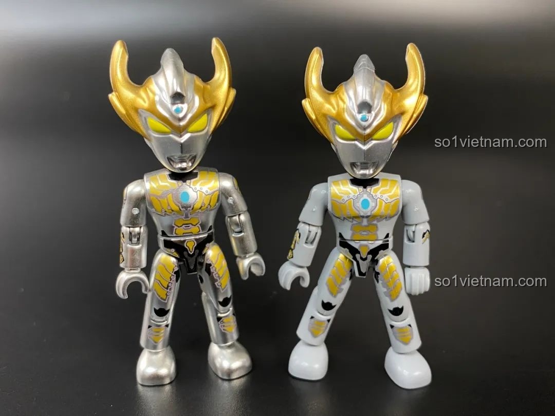 So sánh giữa hai phiên bản của figure Ultraman Taiga, một bản thường và một bản sơn bóng.