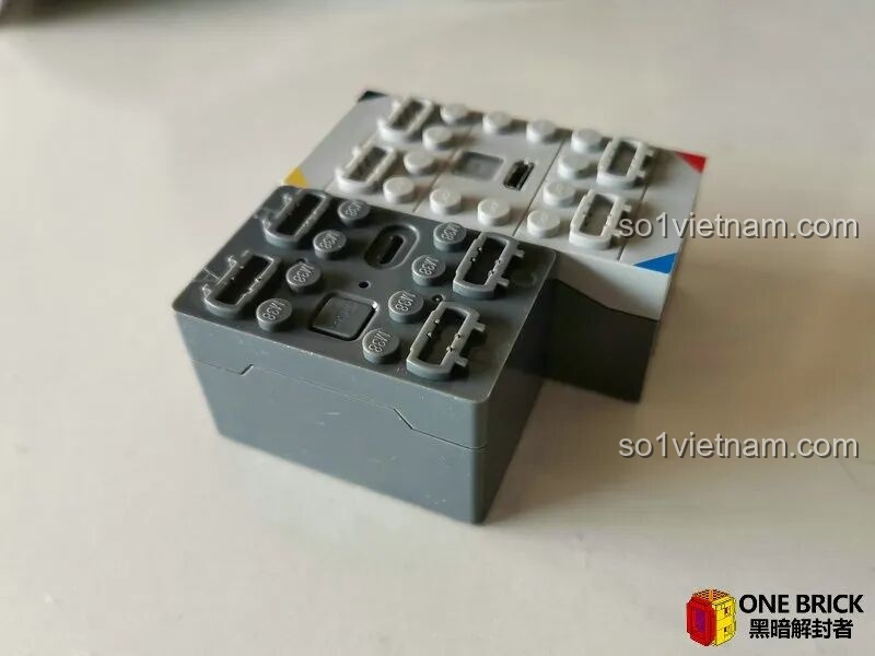 So sánh kích thước hộp pin của Sluban M38B0851 (màu xám) với hộp pin của hãng khác, cho thấy thiết kế nhỏ gọn vượt trội.