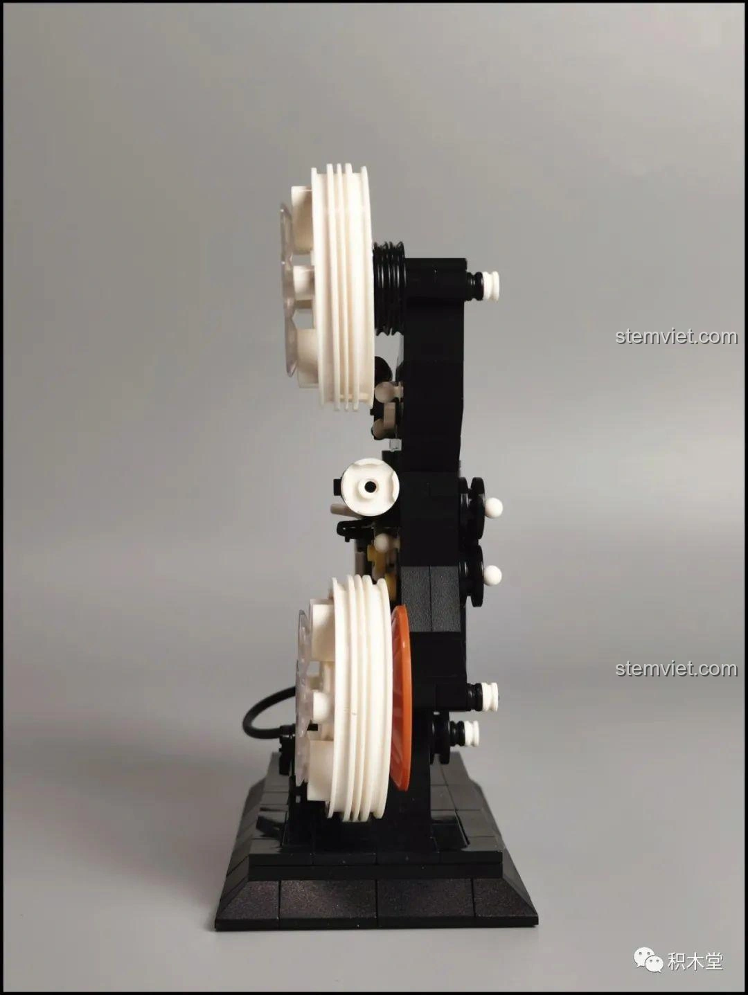 So sánh kích thước mô hình máy chiếu phim cổ điển Zhegao 00907 với một chiếc xe Lego 6 stud.