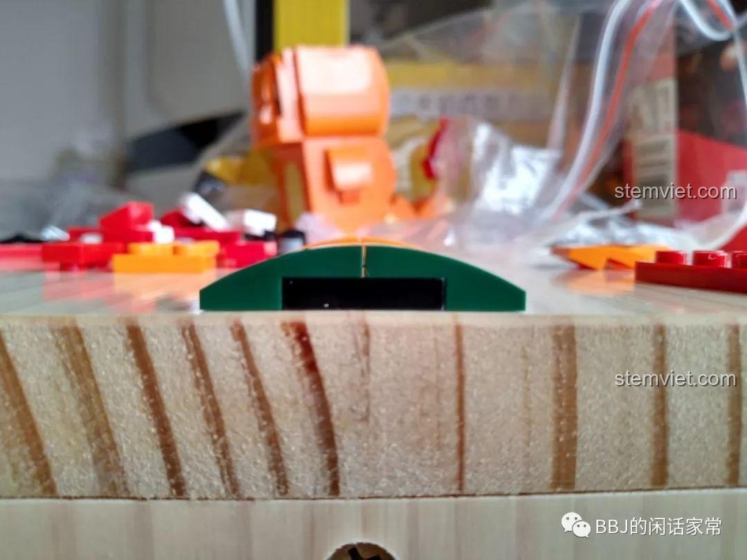 Một mảnh ghép cong tương tự của LEGO được đặt trên mặt phẳng, cho thấy độ phẳng và độ khít hoàn hảo không có khe hở.