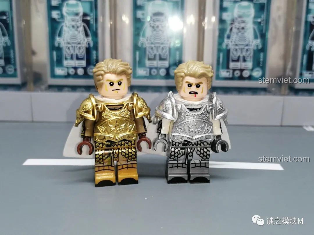 So sánh hai minifigure Mandon Moore từ bộ KORUIT, một mặc giáp vàng và một mặc giáp bạc, đứng cạnh nhau.