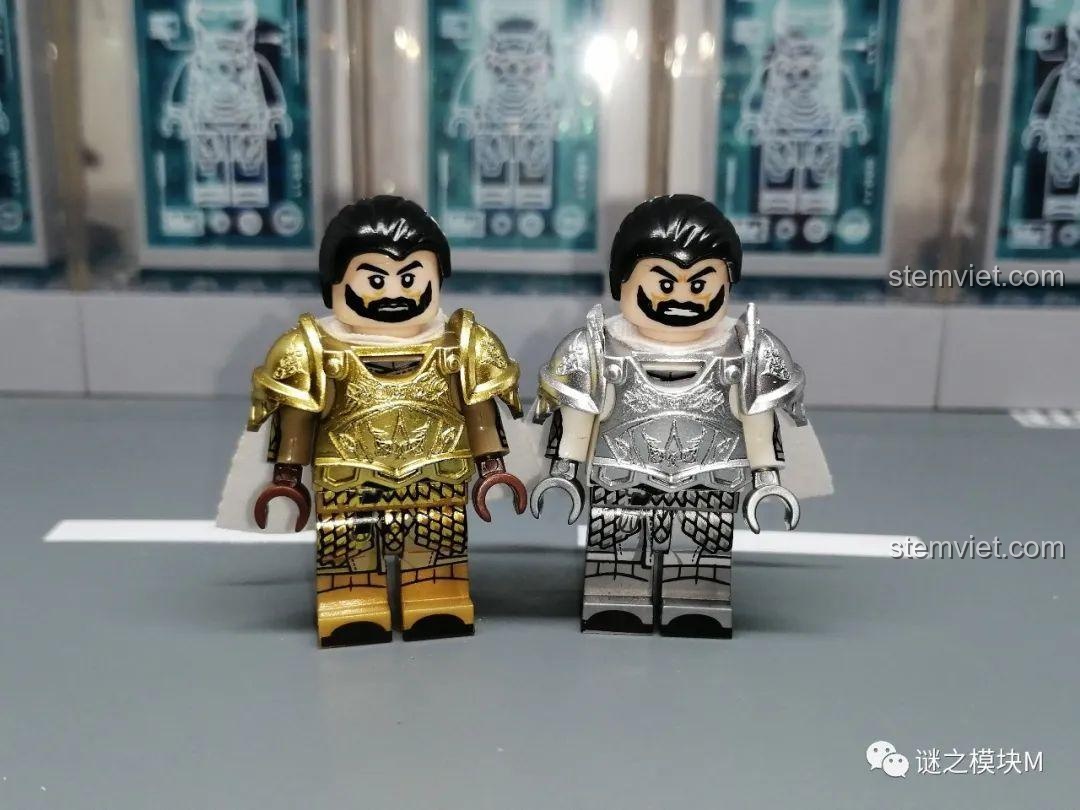 So sánh hai minifigure Meryn Trant từ bộ KORUIT, một mặc giáp vàng và một mặc giáp bạc, đứng cạnh nhau.