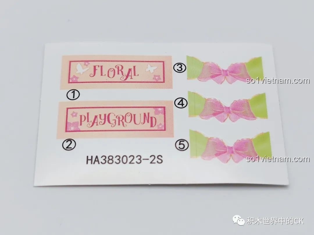 Tờ sticker đi kèm của bộ hoa Khu Vui Chơi Đá Quý, với biển hiệu 'Floral Playground' và những chiếc nơ.