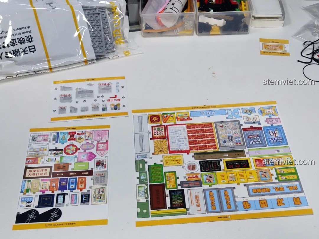 Ba tờ sticker đi kèm bộ Wekki 516954 Cỗ Máy Thời Gian, chứa nhiều hình ảnh trang trí cho các cửa hàng.