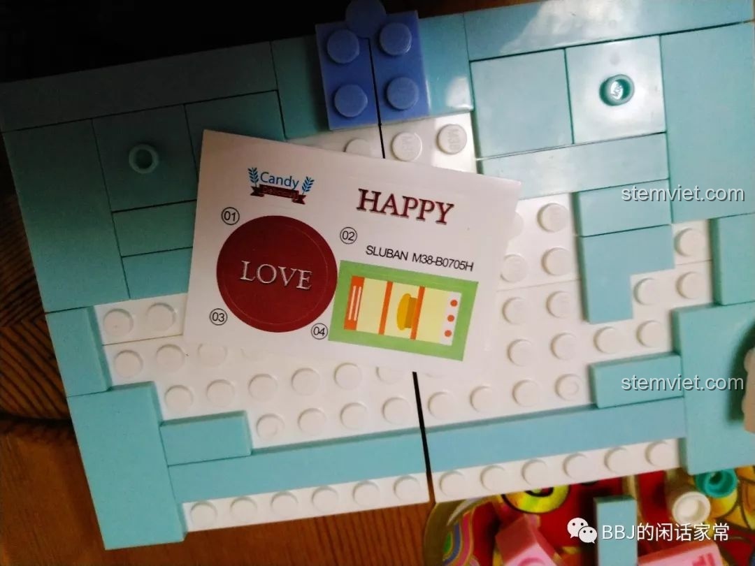 Tấm sticker đi kèm trong bộ lắp ráp Sluban B0705H với các họa tiết 'LOVE', 'HAPPY' và hình ảnh trang trí.
