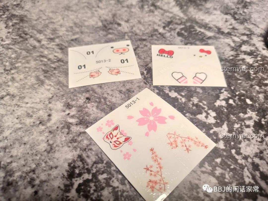 Cận cảnh 3 tấm sticker đi kèm bộ lắp ráp SY 5013 với các chủ đề hoa anh đào, heo con và Hello Kitty.