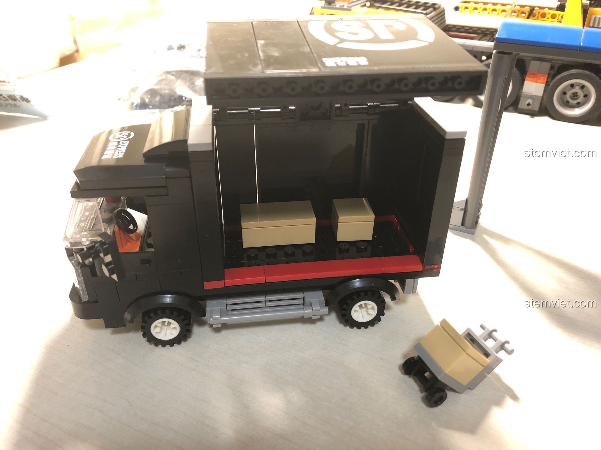 Thùng xe tải vận chuyển SP City Express có thể mở lên, cho phép đặt các kiện hàng vào bên trong, tăng tính chơi.