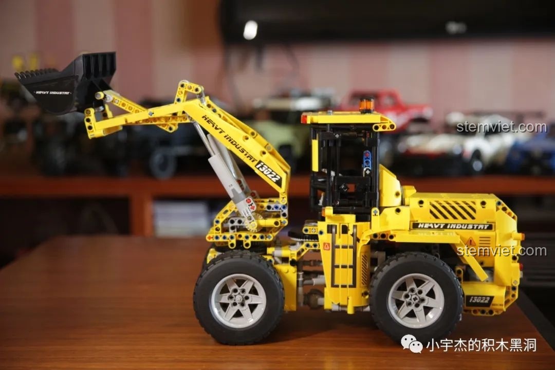 Mô hình xe xúc lật Mould King 13122 với tay đòn được nâng lên cao hết cỡ, thể hiện tầm vươn ấn tượng.