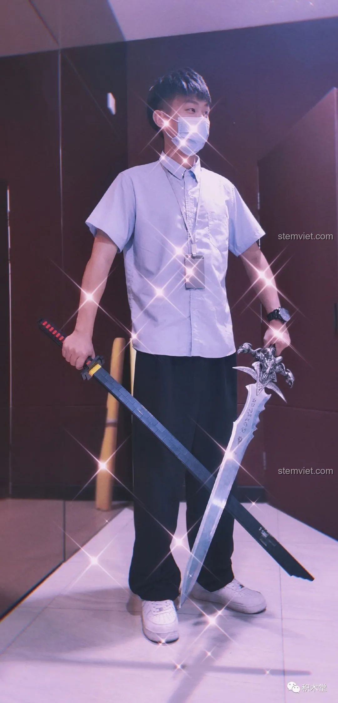 Một bạn trẻ đeo khẩu trang cầm mô hình Thanh kiếm Thiên Tỏa Trảm Nguyệt DK1501 và một thanh kiếm khác, tạo dáng ngầu.