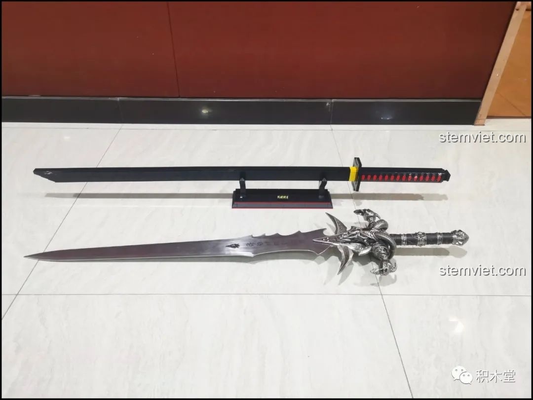 So sánh mô hình Thanh kiếm Thiên Tỏa Trảm Nguyệt DK1501 với một thanh kiếm khác, cho thấy sự khác biệt về kích thước.