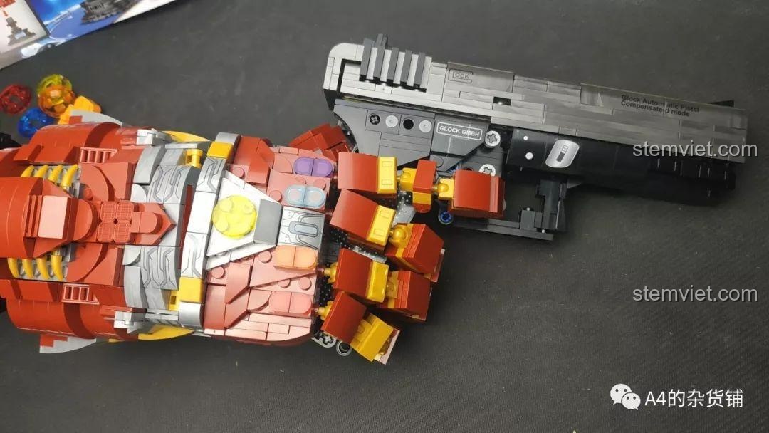 Thành phẩm mô hình SY SY1400 Găng Tay Vô Cực của Iron Man hoàn chỉnh, đặt cạnh bigfig và đế trưng bày.