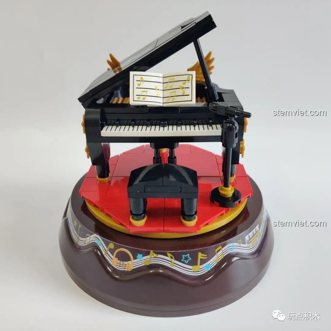 Mô hình hộp nhạc WOMA C0360 Piano hoàn chỉnh với thiết kế đàn dương cầm đen, sân khấu đỏ và đế nhạc.