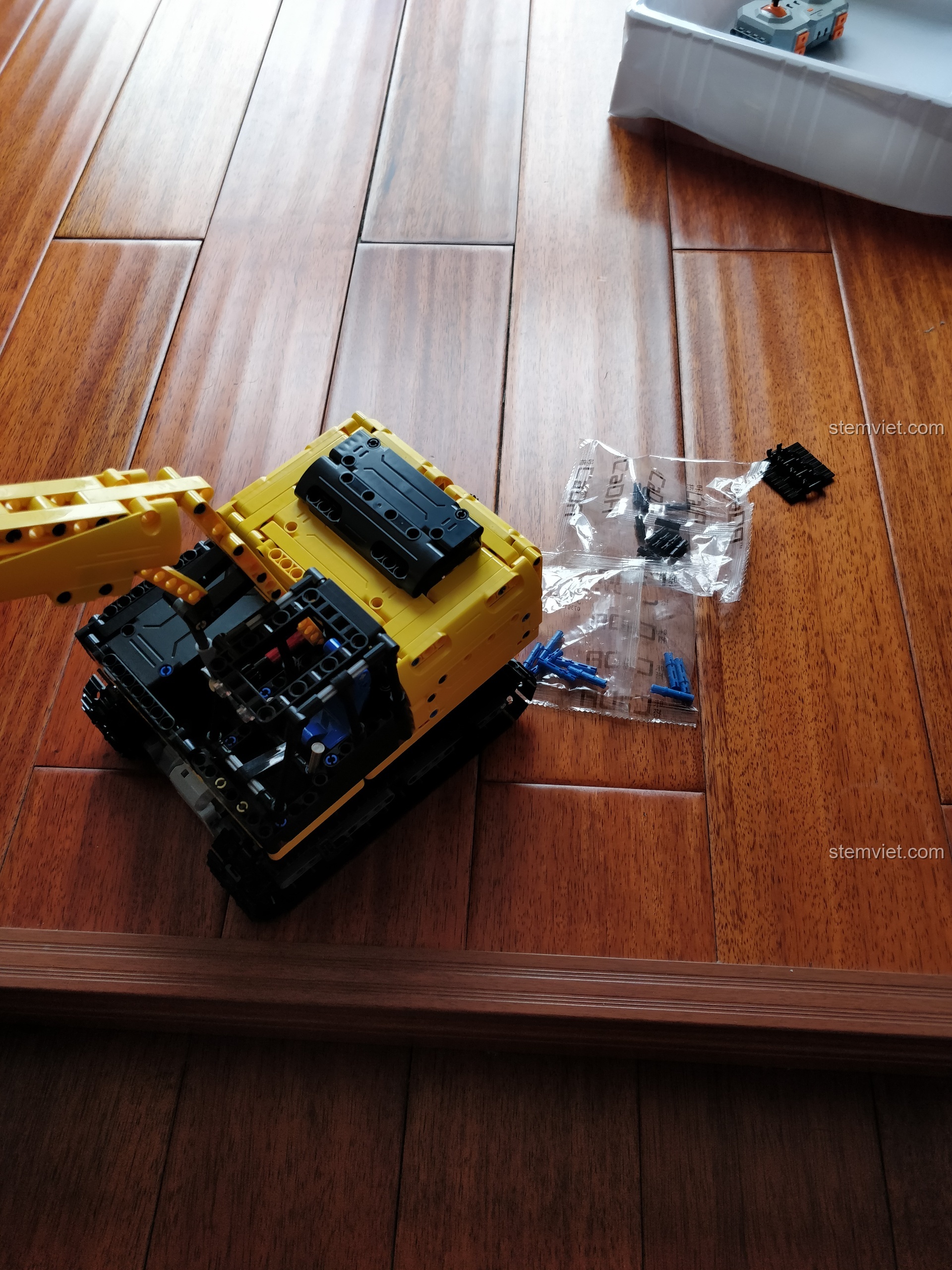 Mô hình máy xúc CaDA C51057 hoàn thiện bên cạnh các chi tiết thừa, một thành quả xứng đáng sau quá trình lắp ráp.