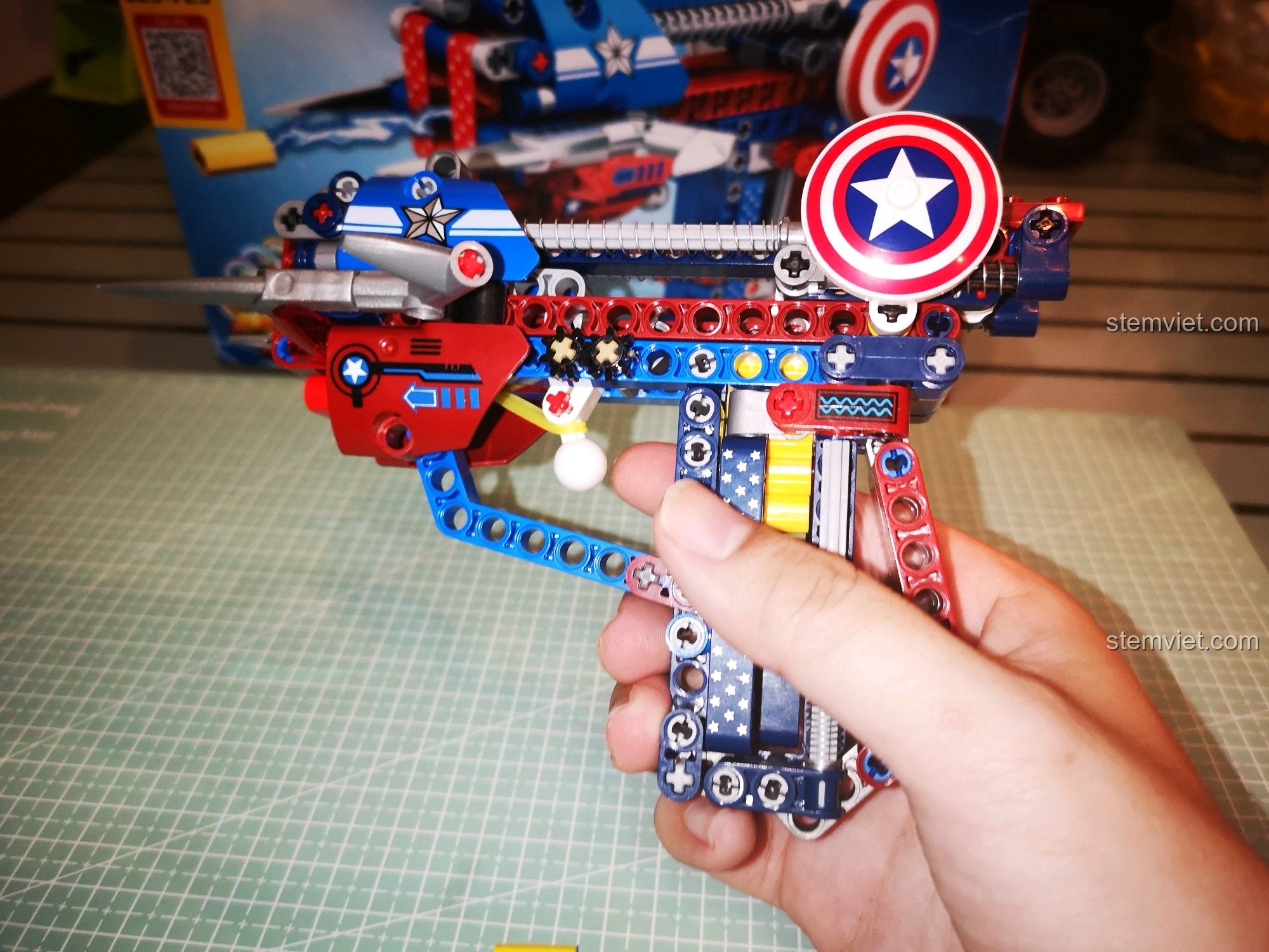 Thao tác bóp cò để bắn của mô hình súng Captain America SY 7018C, thể hiện tính năng độc đáo.
