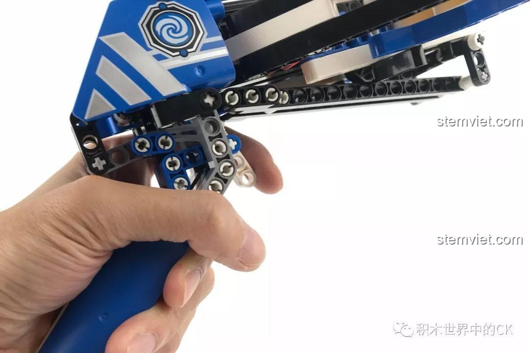 Một bàn tay đang cầm Nỏ Ánh Sáng Thép và bóp cò, thể hiện tính năng chơi của sản phẩm.