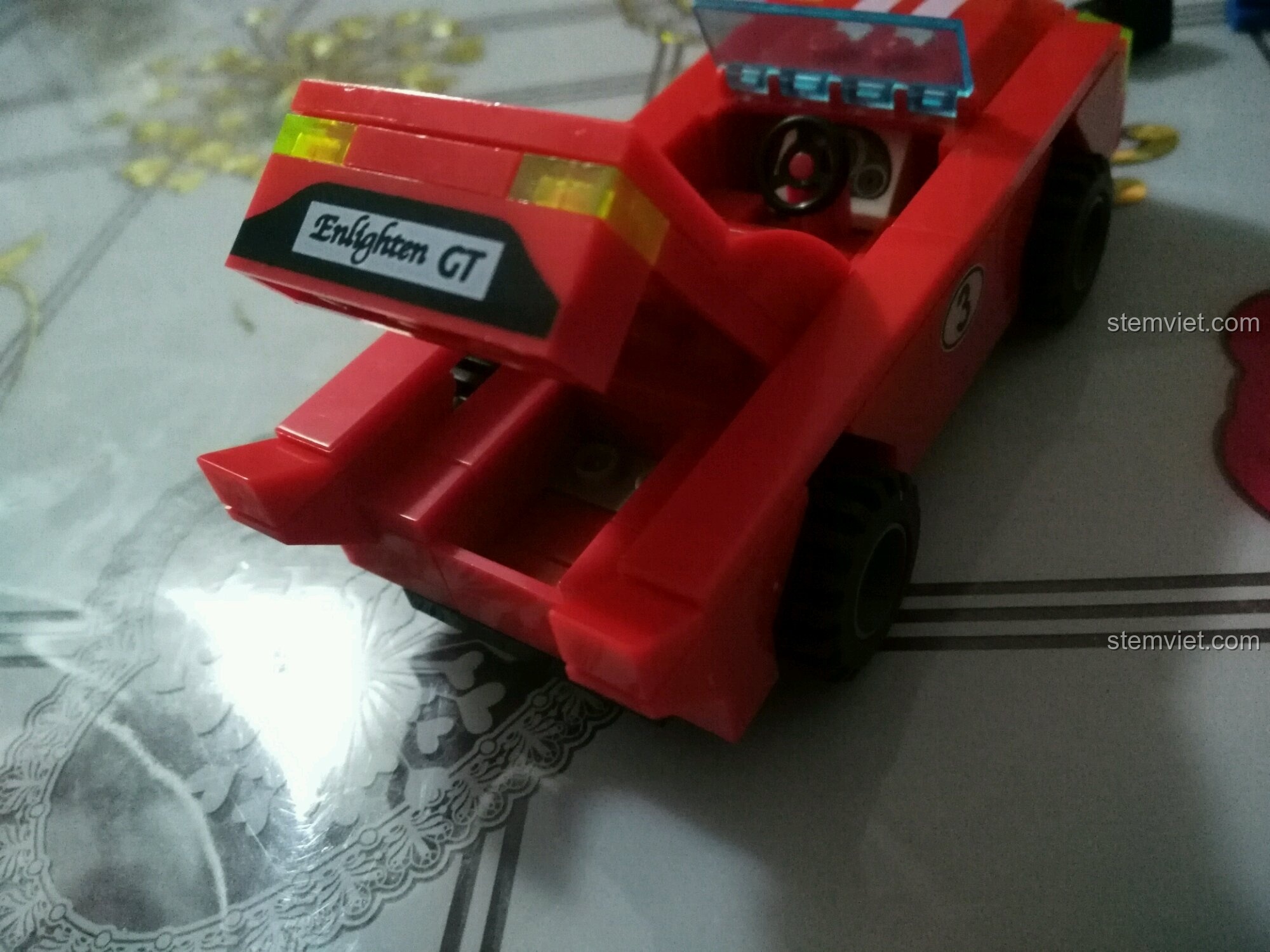 Mô hình xe đua Enlighten 402 với phần cốp sau đang được mở lên, thể hiện tính năng độc đáo.