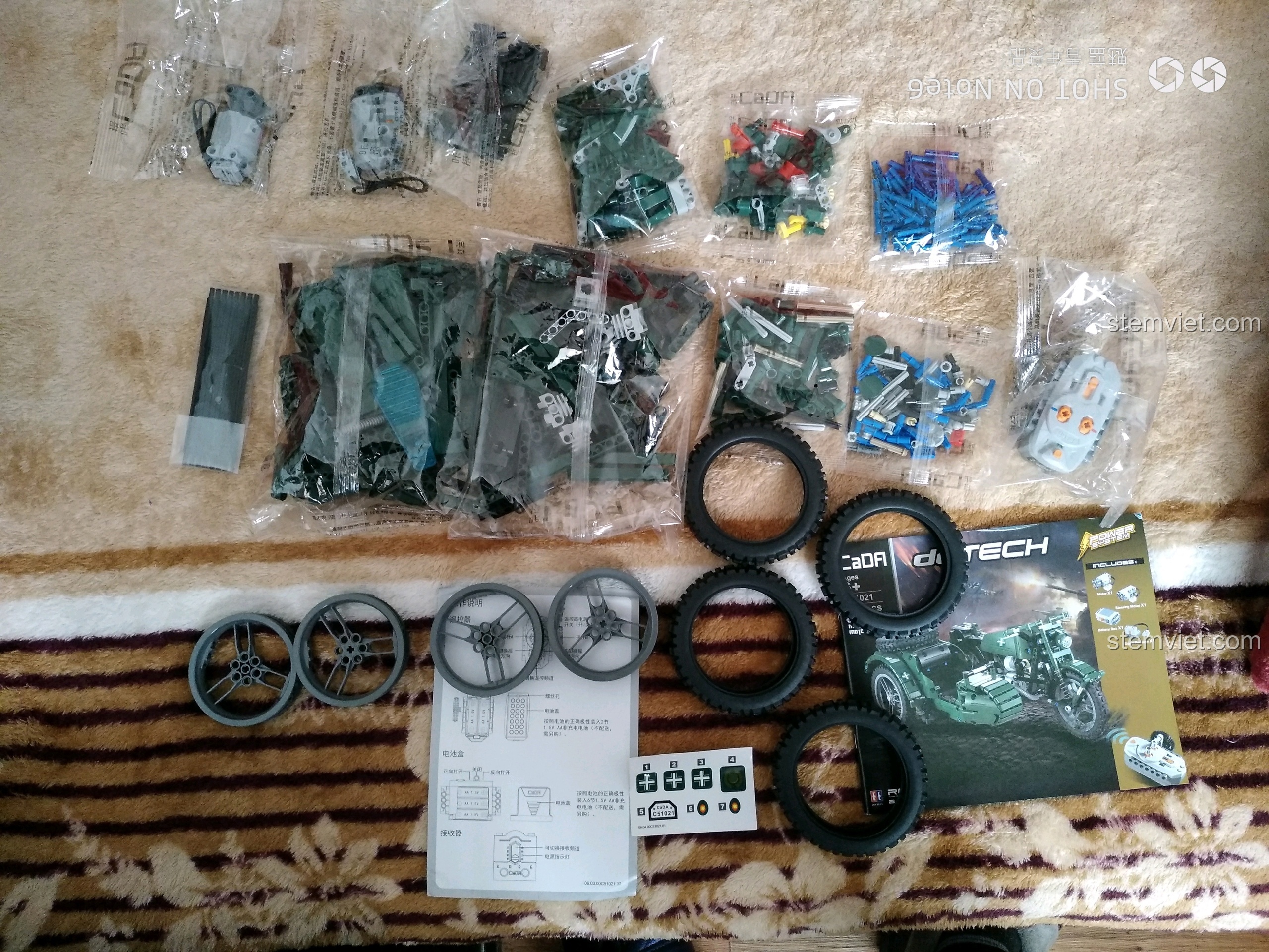 Toàn bộ chi tiết bên trong hộp đồ chơi mô hình xe quân sự Thế chiến II CaDA C51021, bao gồm các túi mảnh ghép, lốp xe, sách hướng dẫn.